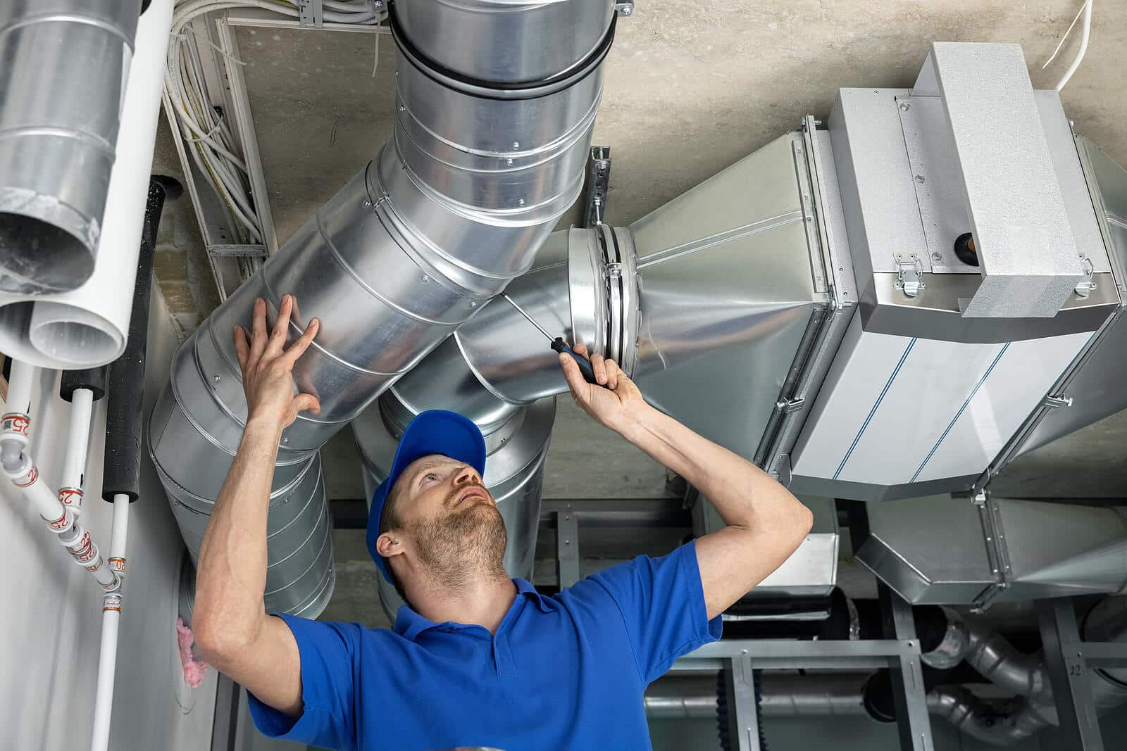 HVAC technician inspecting and repairing air ducts in Sanger