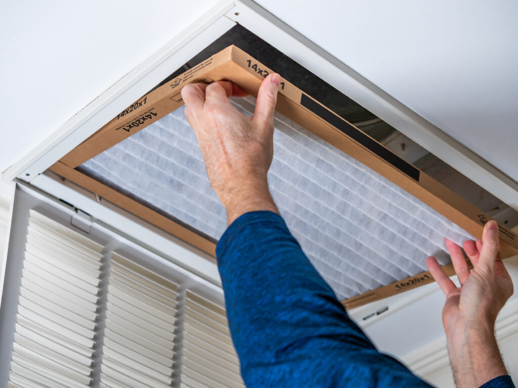 HVAC technician replacing a home air filter in Sanger
