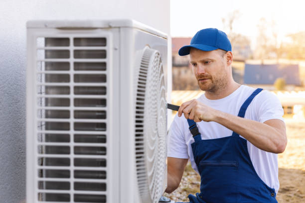 HVAC technician servicing an outdoor air conditioner in Sanger